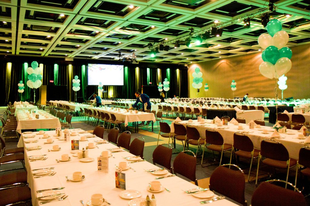 Banquet room at the Québec City Convention Centre with long tables, white tablecloth and white and blue balloons