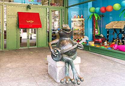 Exterior of Benjo store with large frog statue.