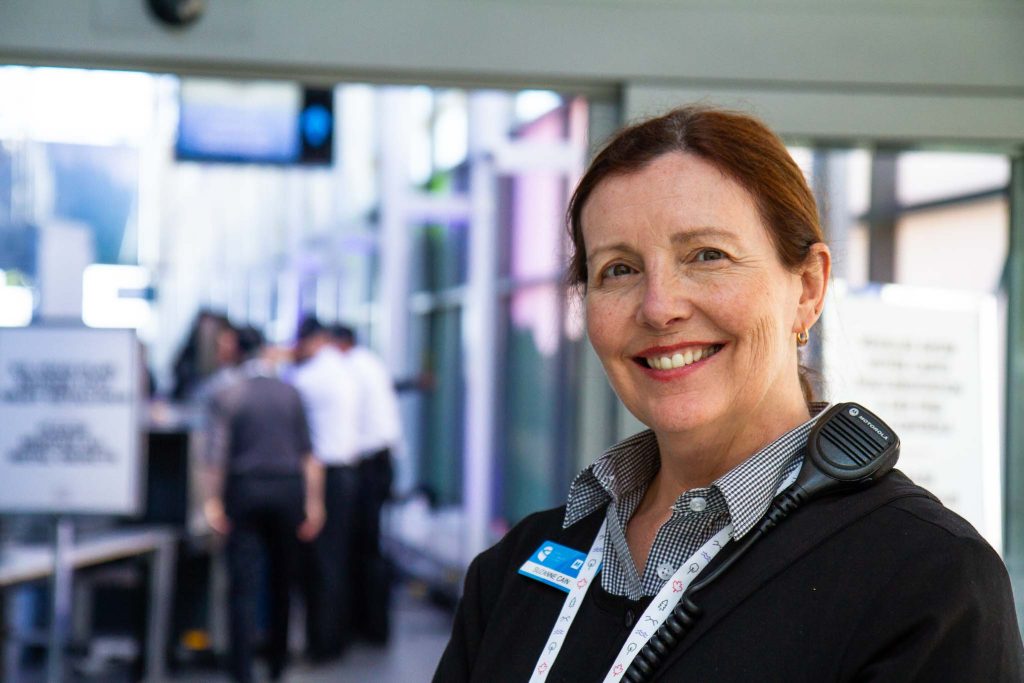 Women with a big smile greeting attendees at the Convention Centre.