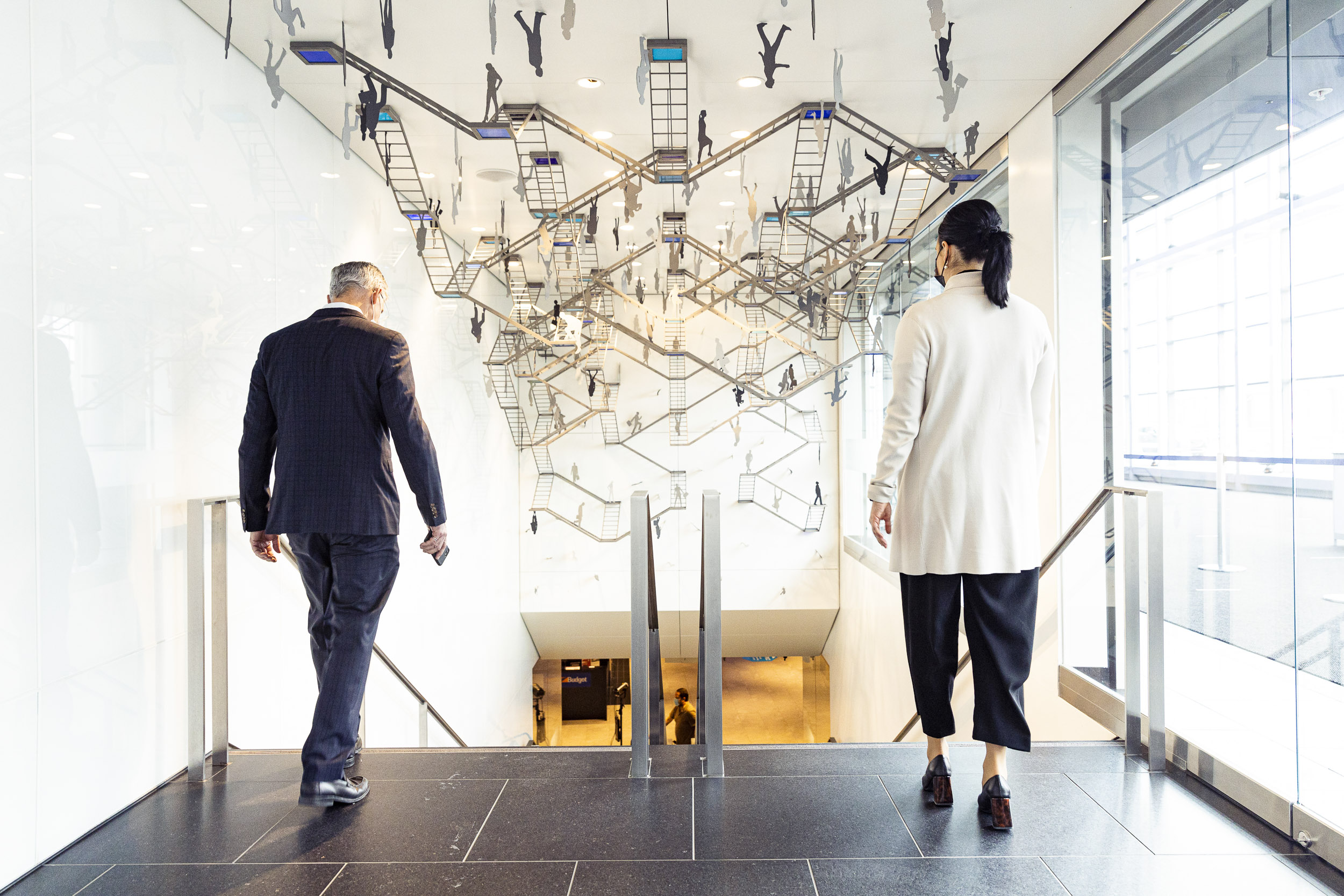 Deux congressistes se dirigeant vers l'Escalier avec l'oeuvre d'art d'un lieu à l'autre de Chantal Seguin
