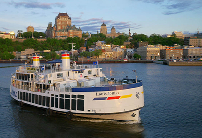Large boat on the St. Lawrence River with Château Frontenac in the background, in the Summer.