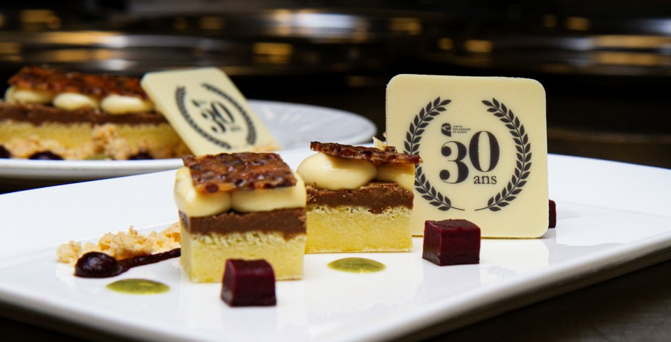 Exclusive dessert for the 30th anniversary of the Québec city Convention Centre, made of the following ingredients: a soft blackcurrant biscuit, fir shoot cream, burst blackcurrant cube and dune pepper crumble, all crowned with a white chocolate piece.