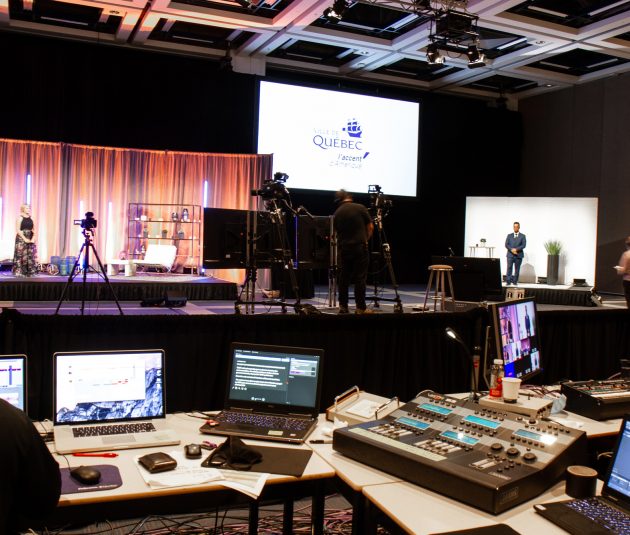 Room at the Québec City Convention Centre set up for a virtual event with AV control room and large screens.