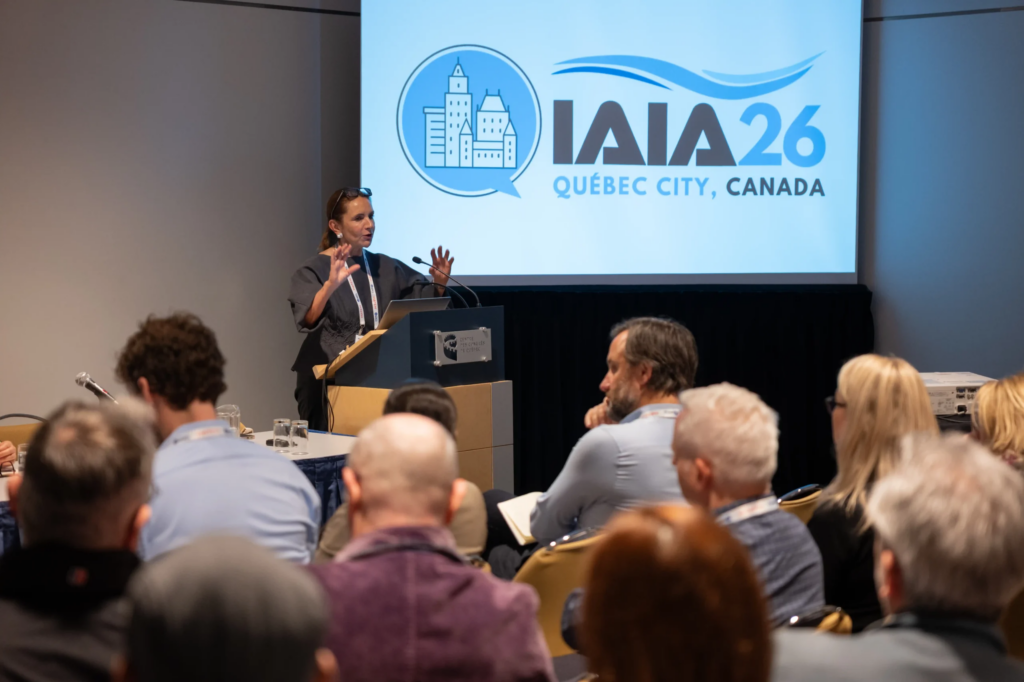 Conférencière prenant la parole devant des congressistes assis dans une salle d'atelier lors du congrès international IAIA26.