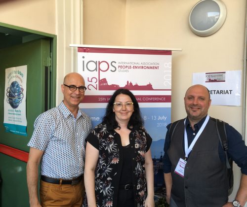 2 men and 1 women standing in front of IAPS 2025 event logo