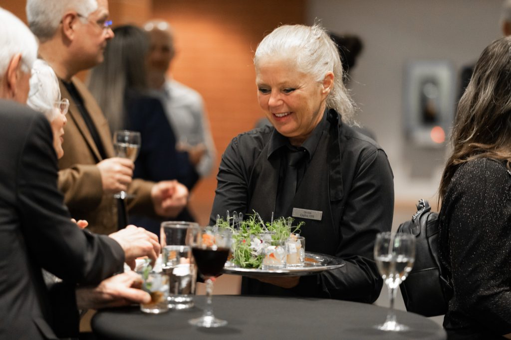Employee serving appetizers at the Hommage aux ambassadeurs 2023 cocktail reception.