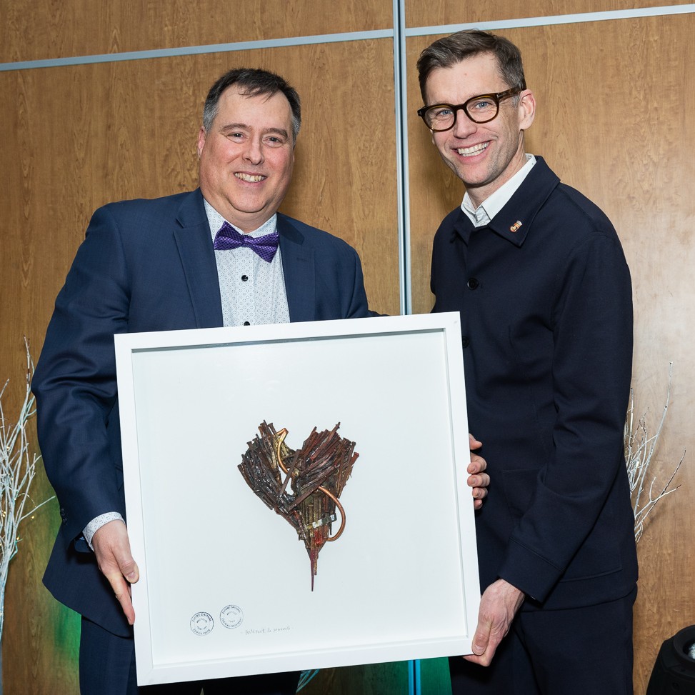 Ambassador Luc Beaulieu holding his “Ambassador of the Year 2024” award, accompanied by the Mayor of Québec City, Mr. Bruno Marchand.