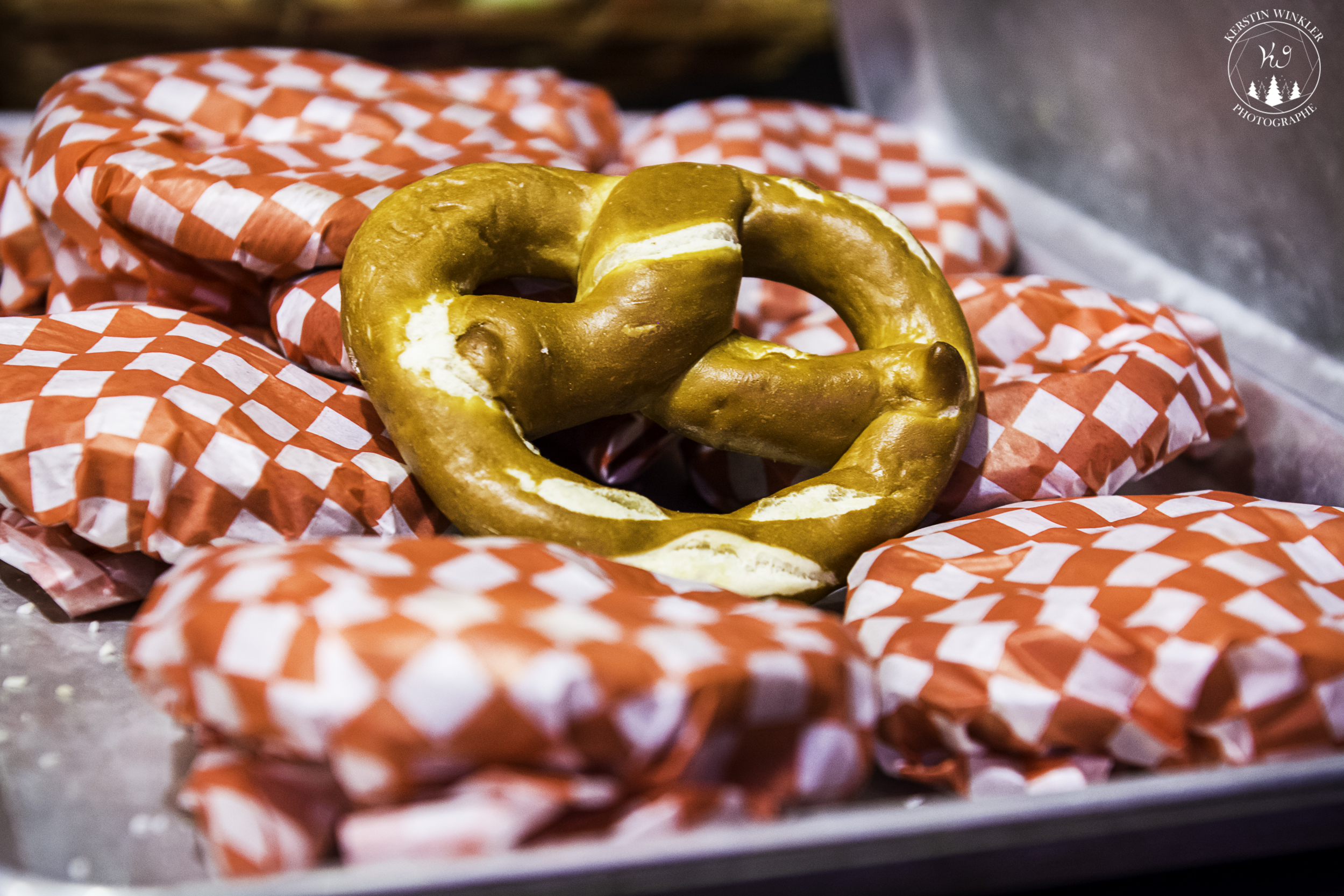 Bretzel déposé sur du papier ciré à carreaux rouges et servi lors du Marché de Noël allemand de Québec