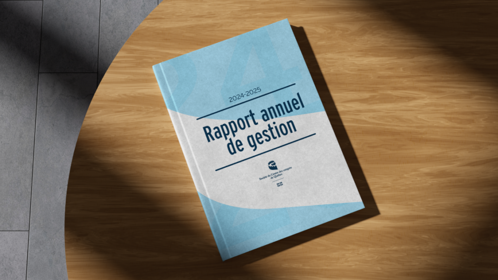 Rapport annuel 2024-2025 de la Société du Centre des congrès de Québec en version imprimée, déposée sur une table de bois.