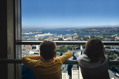 Deux enfants vus de dos, observant la ville de Québec au sommet de l'Observatoire de la Capitale.