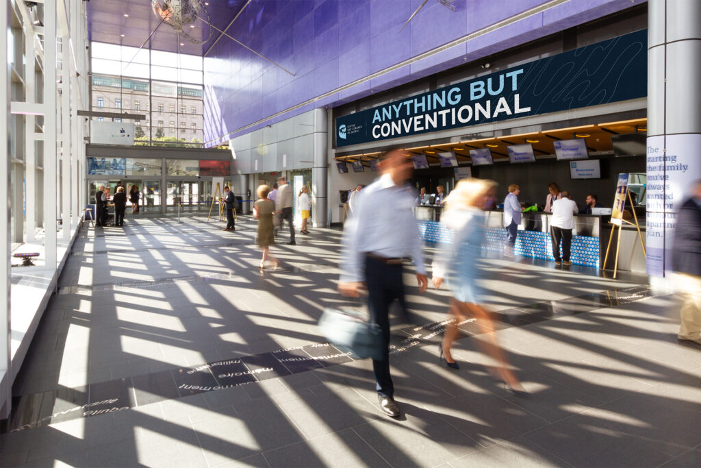 Main hall of the Québec City Convention Centre with a signage screen displaying the slogan "Anything but conventional".