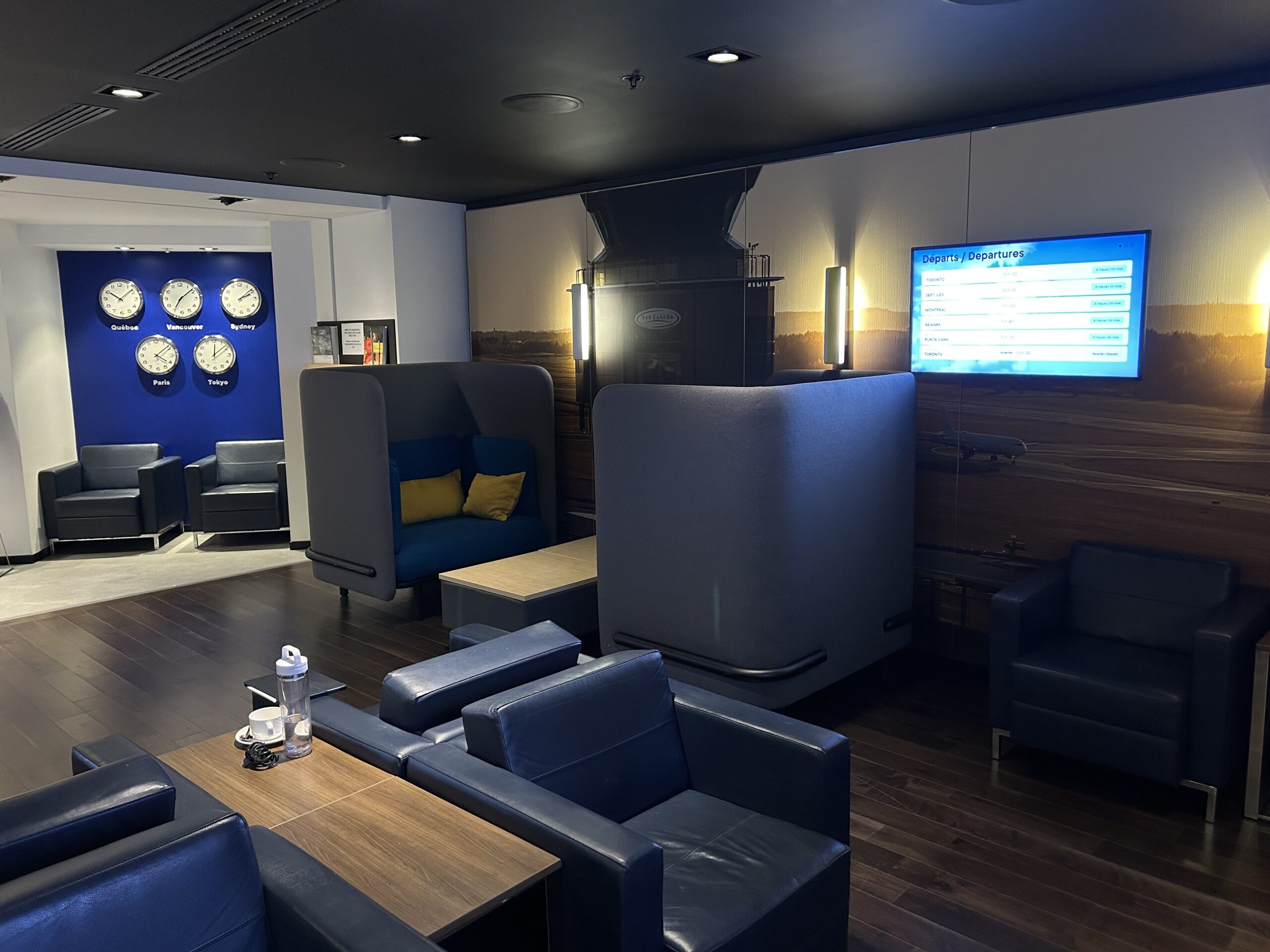 Salon YQB (formerly the Lounge) with blue armchairs and gray banquettes.