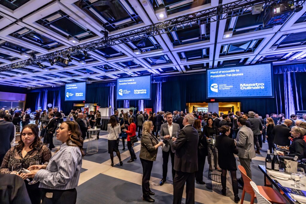 Groupe de gens discutant dans la salle 200 lors de l'événement Soirée Exquise 2024.