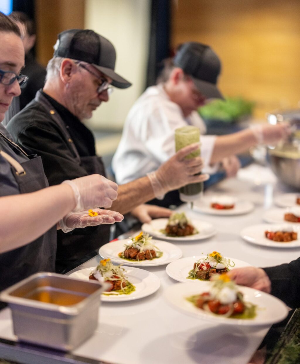 L'équipe de Maestro Culinaire en train de préparer des entrées pour les convives du banquet caritatif Soirée Exquise 2024.