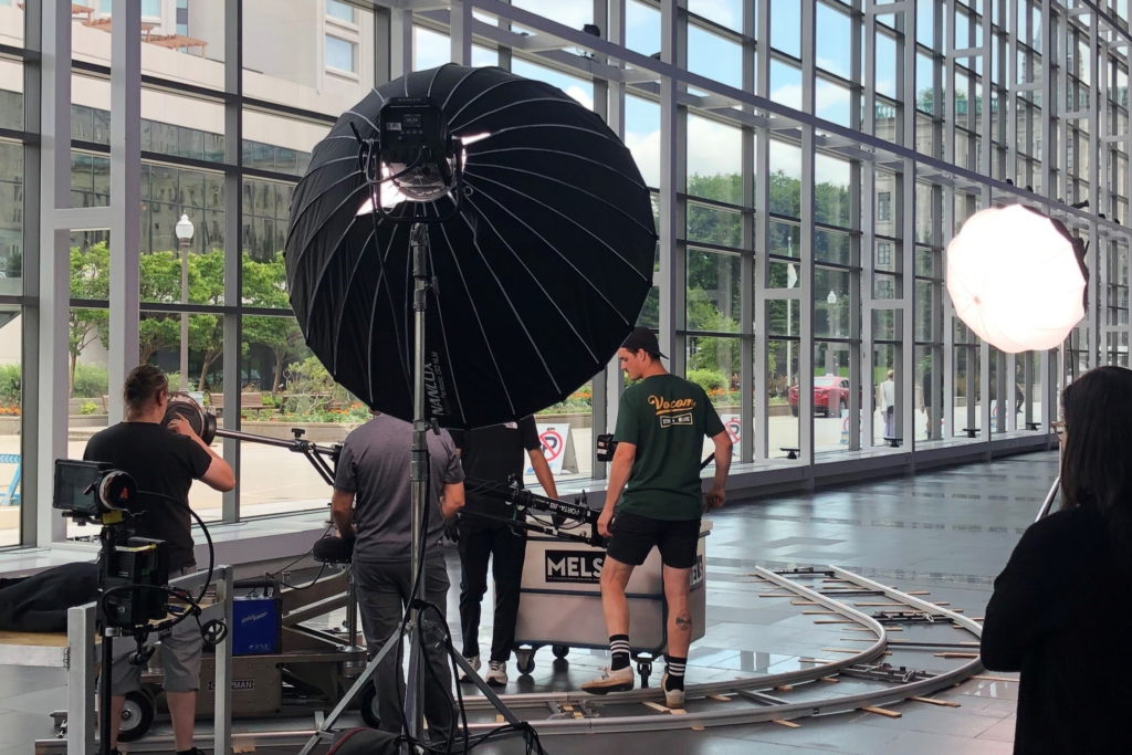 Production crew in action during the filming of the “Anything but Conventional” promotional video, setting up equipment in Room 400 with the dance troupe.