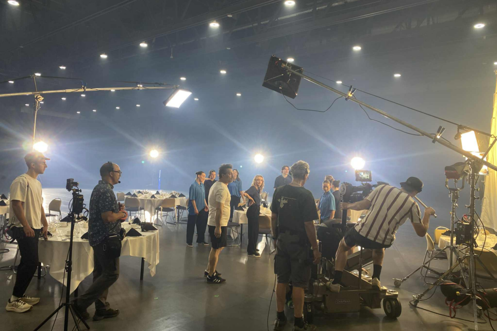 Production crew in action during the filming of the “Anything but Conventional” promotional video, setting up in Room 400.