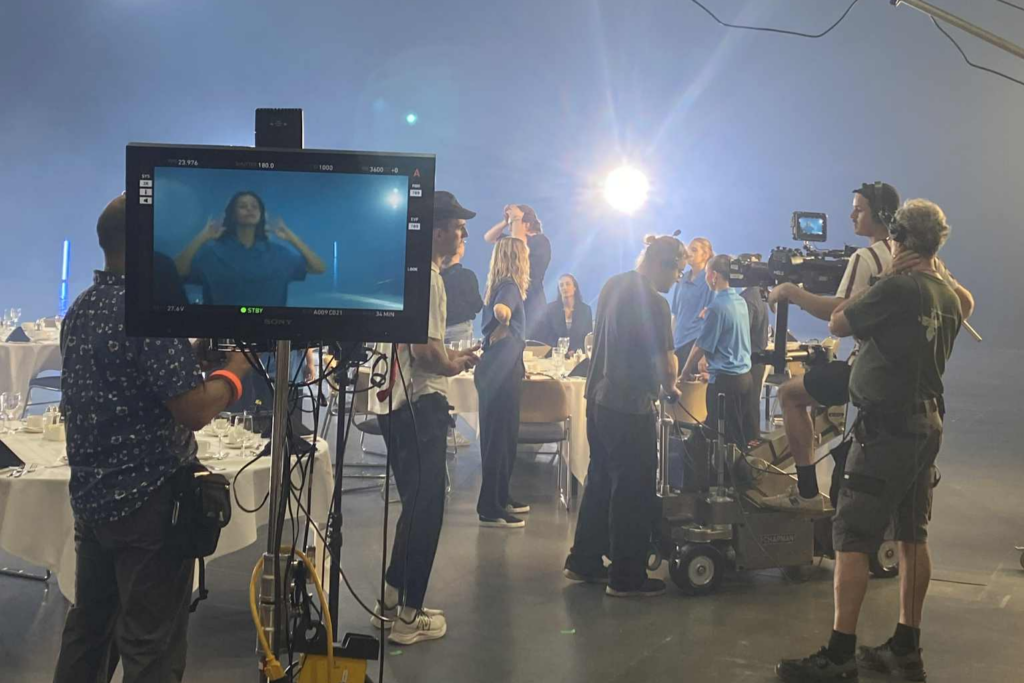 Production crew in action during the filming of the “Anything but Conventional” promotional video, setting up equipment in the main hall.