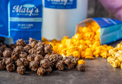 Chocolate and cheese popcorn spilled on a table.