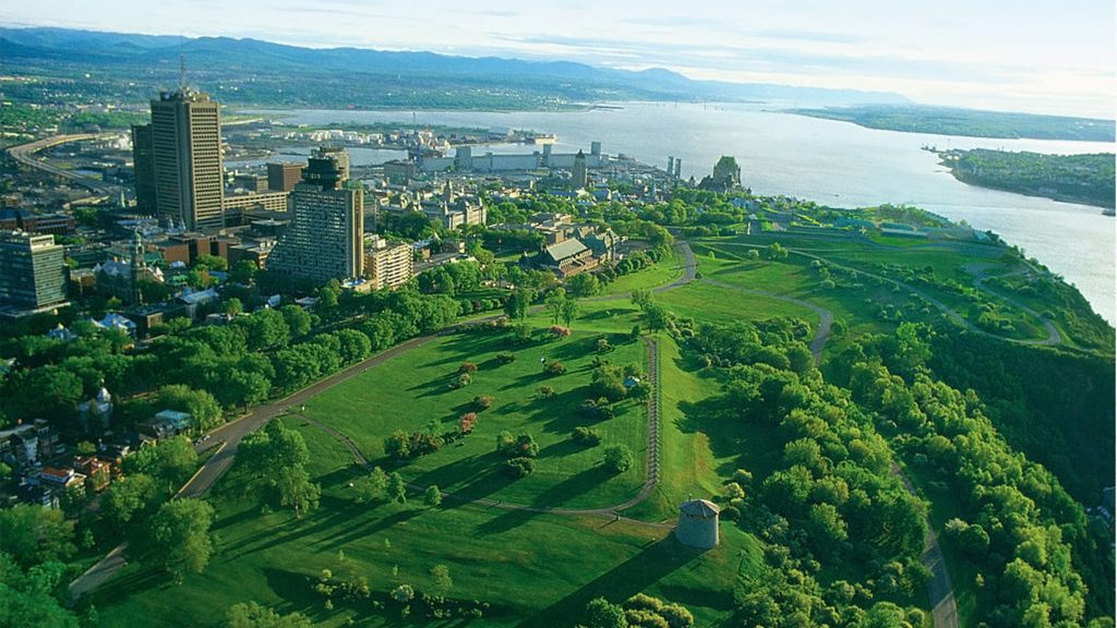 Plaines d'Abraham à vue d'oiseau, en été avec les tour Martello. On y voit le Chateau Frontenac au loin et le fleuve.