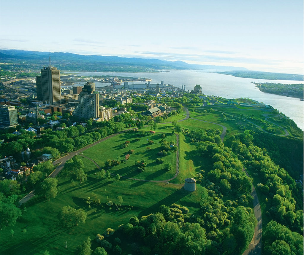 Plaines d'Abraham à vue d'oiseau, en été avec les tour Martello. On y voit le Chateau Frontenac au loin et le fleuve.