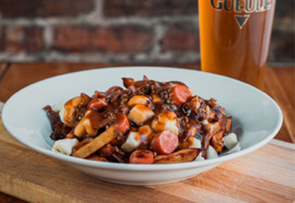 Poutine with sausages with a glass of beer.