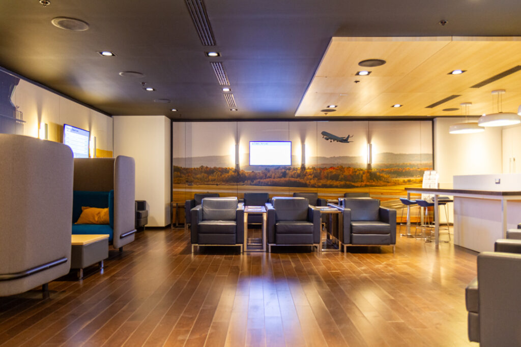 Salon YQB with lounge seating, information screens and decor inspired by Québec City Jean Lesage International Airport.