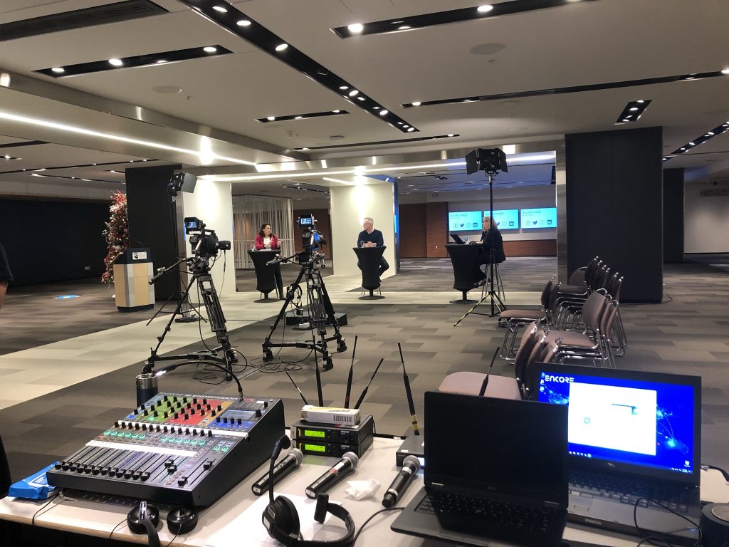 3 directeurs sont sur un plateau de tournage au Centre des congrès de Québec. On y voit la console audiovisuelle.