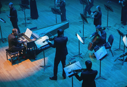 Orchestra on a stage with violons, pianist.